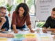 KI-generiertes Bild: Eine vielfältige Gruppe Erwachsener arbeitet gemeinsam an Schutzstrukturen und Kinderschutz. Auf dem Tisch liegen Puzzleteile und Arbeitskarten zu Menschen, Beziehungen, Strukturen und Sozialraum.