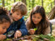 Vier Kinder entdecken gemeinsam mit einer Lupe Pflanzen, Moos und kleine Fundstücke auf einem Baumstamm im Wald. KI-generiertes Bild.