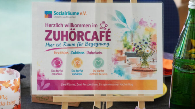 Veranstaltungsfoto vom ersten Erzähl- und Zuhörcafé von Sozialräume e.V. am 4. Oktober 2026 im Städtischen Familienzentrum Kaarst-Mitte in der Büdericher Straße. Zu sehen ist die Willkommenstafel des Zuhörcafés mit dem Leitgedanken „Erzählen. Zuhören. Dabeisein.“ sowie ein Teil des vorbereiteten Cafébereichs.